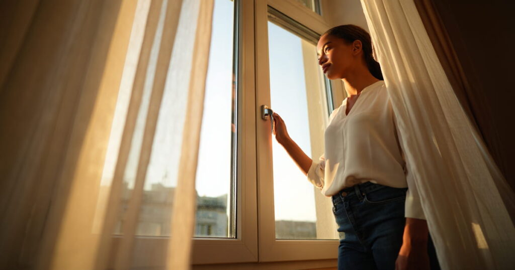 how to give him space without losing him woman standing at window calm and graceful